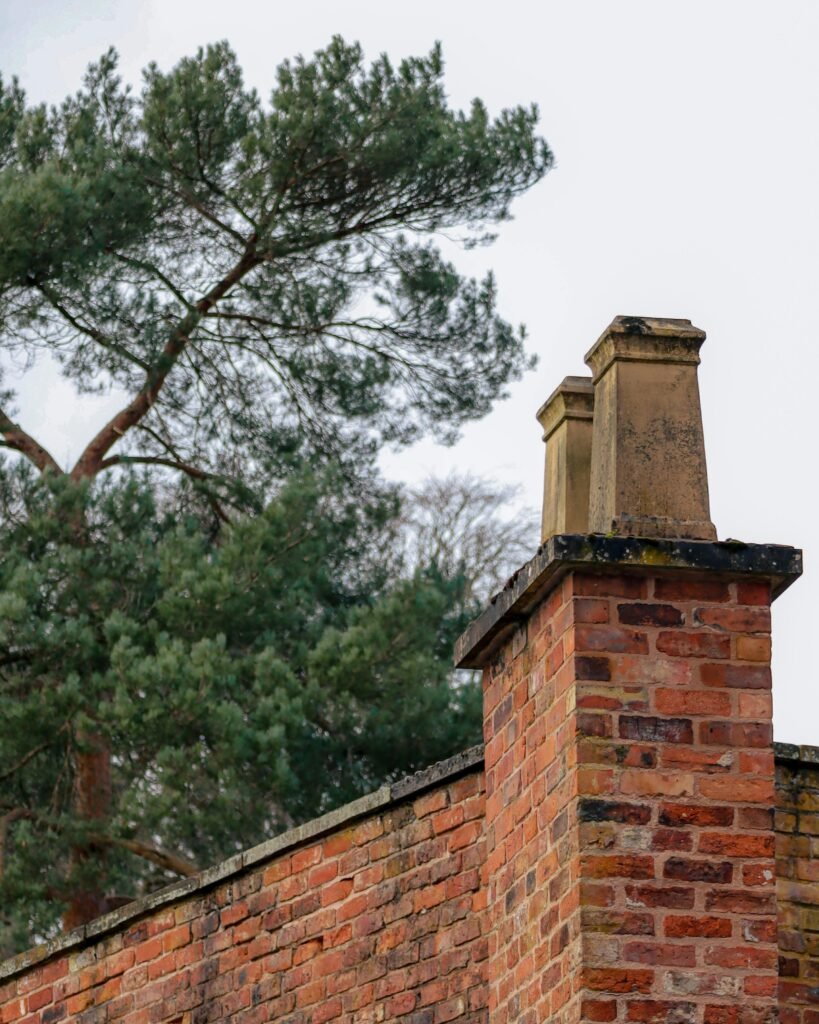 pexels photo 16172158 16172158 A classic brick chimney surrounded by lush greenery in an outdoor setting.